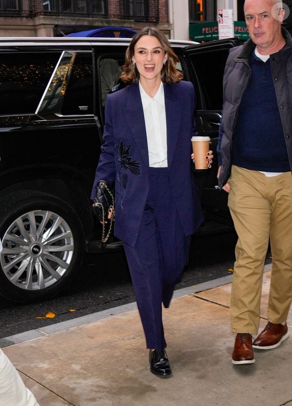 12/10/2024 Keira Knightley is pictured stepping out after a wardrobe change in New York City. The English actress carried a Chanel bag and wore a blue blazer, matching trousers, white blouse, and black shoes.