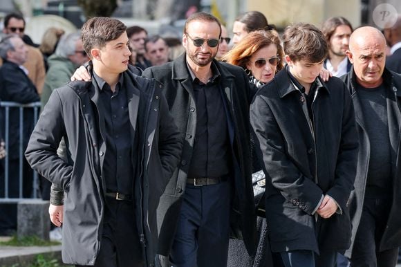 Impossible donc de savoir ce que c'était, mais le veuf d'Emilie Dequenne, également soutenu par ses deux fils, semblait en tout cas très ému par ce geste.

Le veuf Michel Ferracci et ses fils, Enzo et Maël aux arrivées des obsèques d'Emilie Dequenne au cimetière Père Lachaise à Paris, France, le 26 mars 2025. © Cyril Moreau/Bestimage