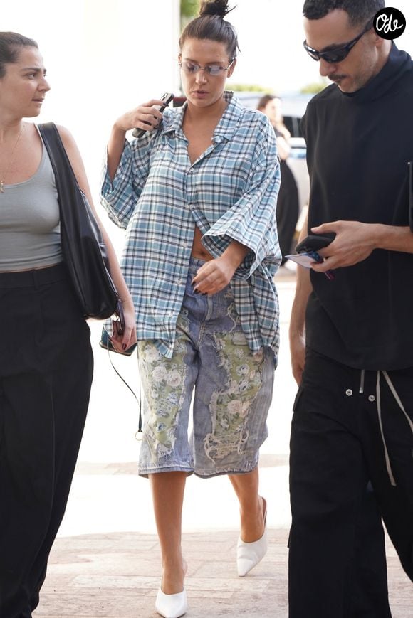 Adèle Exarchopoulos a été aperçue sur la Croisette, durant le Festival de Cannes, vêtue d'une veste à carreaux bleu clair associée à un pantacourt en jean déchiré agrémenté de détails en dentelle, d'escarpins blancs à bouts pointus et d'un grand sac cabas Cannes. Backgrid USA / Bestimage
