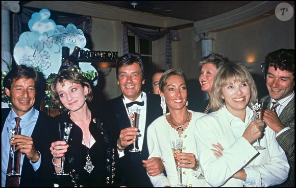 Archives - Patricia Kaas, Alain Delon et Marie Fugain lors de la soirée pour le lancement du champagne "Alain Delon" en 1990 à Paris.@ANGELI-RINDOFF / BESTIMAGE
