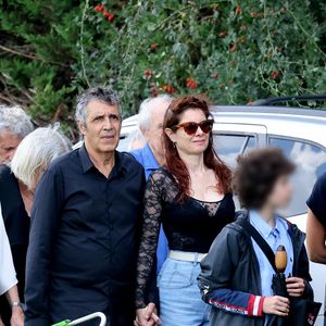 Julien Clerc, sa femme Hélène Grémillon et leur fils Léonard Clerc aux obsèques civiles du journaliste Gérard Leclerc au cimetière des Trois-Moutiers à Loudun, dans la Vienne, France, le 24 août 2023. © Dominique Jacovides/Bestimage