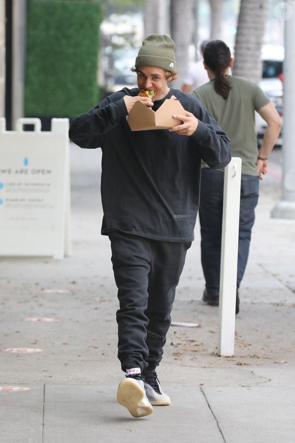 Justin Bieber mange un plat à emporter dans les rues du quartier de Beverly Hills accompagné de son garde du corps à Los Angeles pendant l'épidémie de coronavirus (Covid-19). Justin Bieber dévoilera son nouveau single ‘Holy’ le vendredi 18 septembre, un morceau qui marquera une nouvelle ère pour le chanteur. Le 17 septembre 2020 Backgrid USA / Bestimage