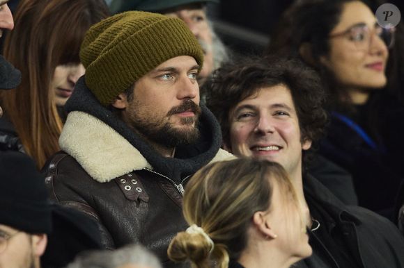 Lucas Bravo et Vincent Lacoste - Célébrités dans les tribunes lors du match de Ligue 1 McDonald's opposant le Paris Saint-Germain (PSG) à l'Olympique de Marseille (OM) - (3-1) au Parc des Princes à Paris le 16 mars 2025. © Cyril Moreau/Bestimage