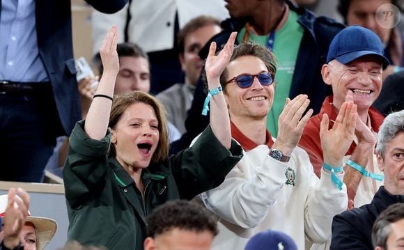 Notons que sur le cliché, les deux tourtereaux ont quand même une bouteille de champagne à la main pour faire honneur à la soirée.

Mélanie Thierry et son compagnon le chanteur Raphaël dans les tribunes lors des Internationaux de France de Tennis de Roland Garros 2025, à Paris, France, le 4 juin 2025. © Jacovides-Moreau/Bestimage