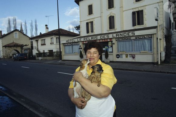 Archives - Maïté (Marie-Thérèse Ordonez) pose à son restaurant  "Le relais des Landes" à Rion-des-Landes en 1992. Elle pose avec ses deux chiens, Sissi et Alto, des Pinscher nain

© Alain Canu via Bestimage