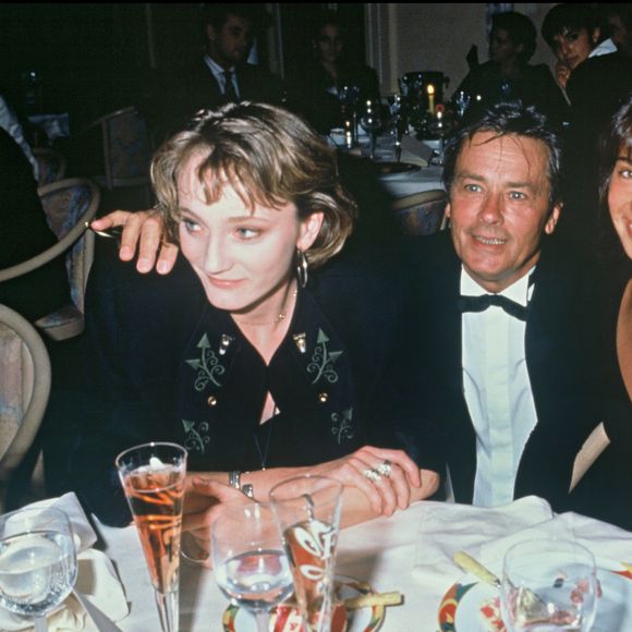 Archives - Patricia Kaas, Alain Delon et Marie Fugain lors de la soirée pour le lancement du champagne "Alain Delon" en 1990 à Paris.@ANGELI-RINDOFF / BESTIMAGE