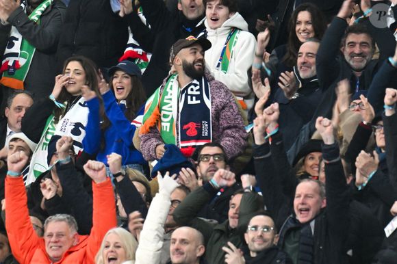 Iris Mittenaere, Jean Dujardin, Oli - Célébrités dans les tribunes du match d'ouverture du Tournoi des six nations : France-Irlande (36-14) au Stade de France à Saint-Denis le 5 février 2026. © Lionel Urman/Bestimage
