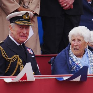 Le roi Charles III d'Angleterre, Joy Trew - Le roi Charles III s'adresse à l'ancienne combattante Joy Trew lors du défilé militaire organisé à l'occasion du 80e anniversaire du jour de la Victoire en Europe, en l'honneur de ceux qui ont servi pendant la Seconde Guerre mondiale, au palais de Buckingham, le 5 mai 2025, à Londres, en Angleterre. (Mirrorpix / Bestimage)