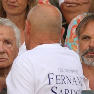 Semi-exclusif - Michel Sardou, Romain Sardou - Michel Sardou rend hommage à son père en famille lors du premier trophée de pétanque "Fernand Sardou" à Bormes-les-Mimosas le 29 mai 2026. Le célèbre chanteur est venu en famille avec sa femme, son fils Romain avec son fils de deux ans et demi et de sa compagne enceinte de son deuxième enfant.
La première édition du Trophée Fernand Sardou est organisée du 29 au 31 mai au coeur du village de Bormes les Mimosas. Une initiative portée par Michel et son fils Romain, pour rendre hommage à leur illustre parent Fernand Sardou au travers d'un tournoi de pétanque.
En lien avec la municipalité et l'Amicale Bouliste Borméenne (ABB), un premier Trophée Fernand Sardou sera organisé avec deux grands temps forts : Le vendredi, dès 18h, un tournoi d'exhibition sera proposé et verra s'affronter 16 triplettes. Puis un concours fédéral à pétanque sera organisé le weekend et ouvert à tous les amateurs. 128 équipes seront réparties sur les sites les plus emblématiques du village, à savoir au boulodrome de la place Saint-François, mais aussi au parc Cigalou, sur le site du château et à l'ancien stade. © Franz Chavaroche/Bestimage
