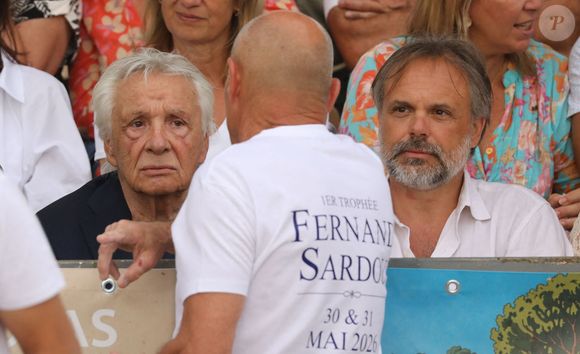 Semi-exclusif - Michel Sardou, Romain Sardou - Michel Sardou rend hommage à son père en famille lors du premier trophée de pétanque "Fernand Sardou" à Bormes-les-Mimosas le 29 mai 2026. Le célèbre chanteur est venu en famille avec sa femme, son fils Romain avec son fils de deux ans et demi et de sa compagne enceinte de son deuxième enfant.
La première édition du Trophée Fernand Sardou est organisée du 29 au 31 mai au coeur du village de Bormes les Mimosas. Une initiative portée par Michel et son fils Romain, pour rendre hommage à leur illustre parent Fernand Sardou au travers d'un tournoi de pétanque.
En lien avec la municipalité et l'Amicale Bouliste Borméenne (ABB), un premier Trophée Fernand Sardou sera organisé avec deux grands temps forts : Le vendredi, dès 18h, un tournoi d'exhibition sera proposé et verra s'affronter 16 triplettes. Puis un concours fédéral à pétanque sera organisé le weekend et ouvert à tous les amateurs. 128 équipes seront réparties sur les sites les plus emblématiques du village, à savoir au boulodrome de la place Saint-François, mais aussi au parc Cigalou, sur le site du château et à l'ancien stade. © Franz Chavaroche/Bestimage