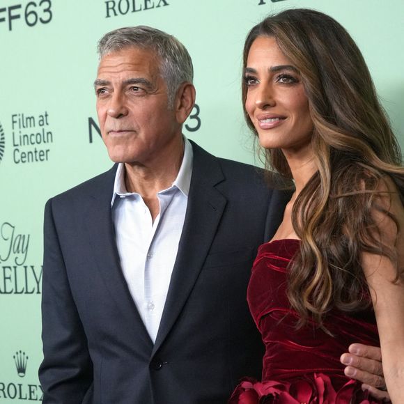Escarpins dorés, pochette assortie et bijoux scintillants complétaient son look.
George Clonney et Amal Clooney assistent à la première sur le tapis rouge de « Jay Kelly » lors de la soirée d'ouverture du 63e Festival du film de New York. Alice Tully Hall, Lincoln Center, New York. 29 septembre 2025.  © Sonia Moskowitz Gordon/ZUMA Press Wire