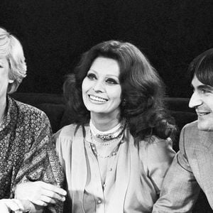 Archive - Serge Lama. En France, à Paris, sur le plateau, assis côte à côte de gauche à droite, se donnant le bras, Alice Dona, en robe, Sophia Loren, en robe et Serge Lama, en en costume cravate. © Michel Ristroph via Bestimage