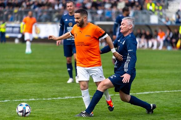 "Soit je m'enfermais dans ma tanière, soit je me décidais à me relever pour revenir plus fort. C'était en avril 2023, j'ai commencé ma première session de sport, au bout de dix minutes à 5km/h j'avais mal partout. Mais j'ai continué pas à pas", a t-il glissé.

Malik Bentalha lors du match caritative au bénéfice de l'Unicef opposant la Team Saône-et-Loire à la Team Unicef au stade Jean-Laville de Gueugnon, France, le 1er avril 2024.  © Pierre Perusseau/Bestimage