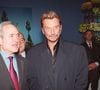 Mais il va alors mettre tout le monde mal à l'aise au sein de l'Hôtel de Ville. Et plus particulièrement son épouse Xavière Tiberi.

Jean Tiberi et Johnny Hallyday présentent le programme 2000 ANGELI-FIZET / BESTIMAGE