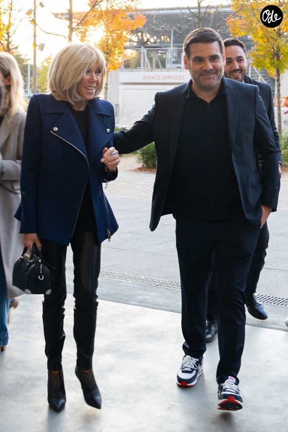 Brigitte Macron et Matthieu Lartot, journaliste et commentateur sportif, fondateur de l'association « La Piste » au sein de l'association « Debout En Bouts ». Trente personnes amputées portant des prothèses défilent sur le court Philippe-Chatrier du stade de Roland-Garros le 8 octobre 2025 à Paris, en France. Photo de Nasser Berzane/ABACAPRESS.COM