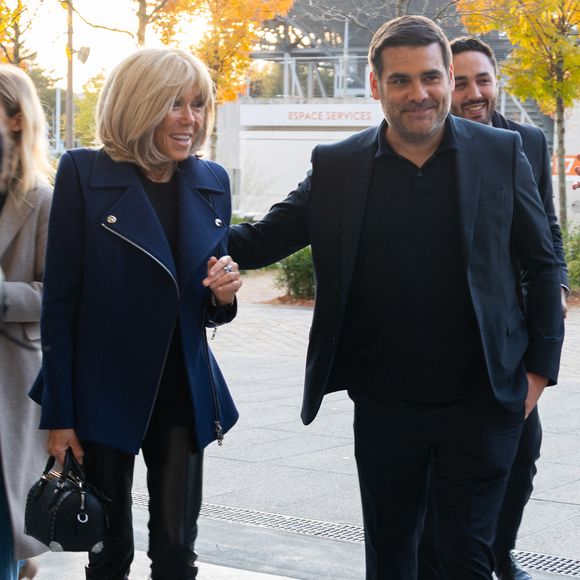 Brigitte Macron et Matthieu Lartot, journaliste et commentateur sportif, fondateur de l'association « La Piste » au sein de l'association « Debout En Bouts ». Trente personnes amputées portant des prothèses défilent sur le court Philippe-Chatrier du stade de Roland-Garros le 8 octobre 2025 à Paris, en France. Photo de Nasser Berzane/ABACAPRESS.COM