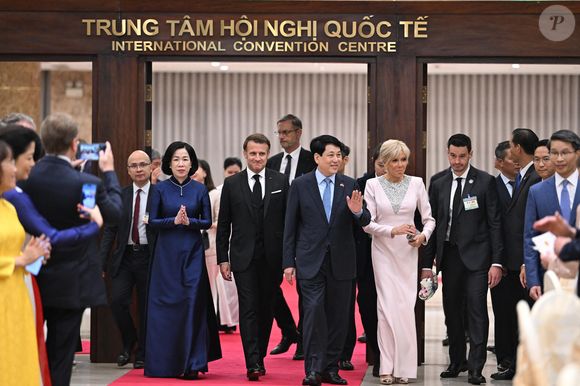 Sa tenue était agrémentée d'une plastron triangulaire gris argenté, d'escarpins chromés à bouts pointus, de boucles d'oreilles pendantes et d'un sac Lady Dior Mini, selon "Gala".

Le président français E. Macron et sa femme B. Macron, aux côtés de son homologue vietnamien Luong Cuong avec sa femme Nguyen Thi Minh Nguyet, lors d'un dîner d'État au Centre international des congrès de Hanoi, au Vietnam, le 26 mai 2025. © Jeanne Accorsini / Pool / Bestimage