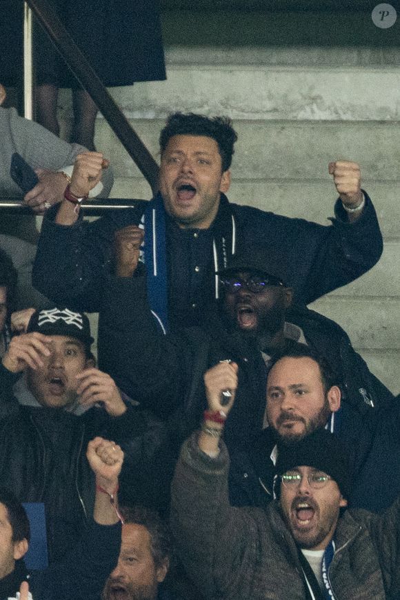 Kev Adams, Issa Doumbia - Célébrités dans les tribunes du match de 8ème de finale aller de la Ligue Des Champions 2025-2026 (LDC) "PSG - Chelsea (5-2)" au Parc des Princes à Paris le 11 mars 2026. © Cyril Moreau/Bestimage