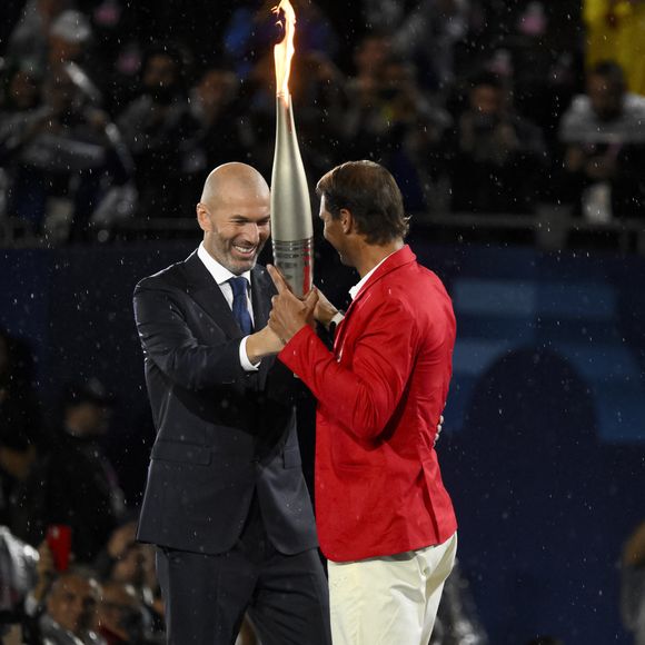 Zinedine Zidane remet la flamme olympique à Rafael Nadal lors de la cérémonie d'ouverture des Jeux Olympiques de Paris 2024 au Trocadéro à Paris (France), le 26 juillet 2024. © Inside/Panoramic/Bestimage