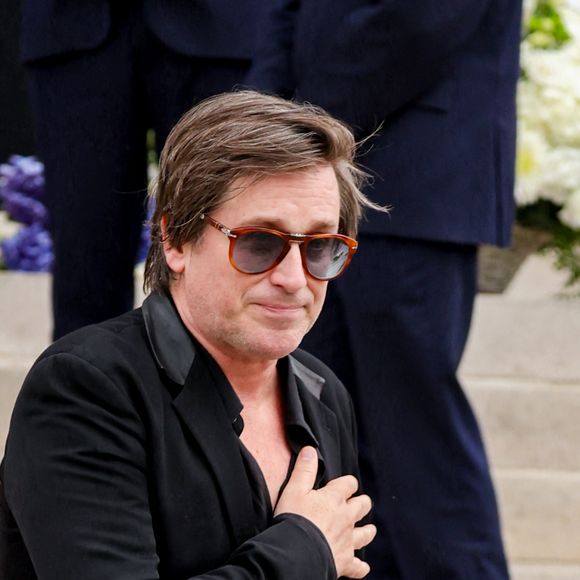 Thomas Dutronc, la main sur le coeur en guise de remerciement envers la foule d'admirateurs venue nombreuse pour rendre un dernier hommage à sa mère - Sortie des obsèques de l'auteure-compositrice-interprète et actrice française Françoise Hardy au crématorium du cimetière du Père-Lachaise à Paris, France, le 20 juin 2024. © Jacovides-Moreau/Bestimage
