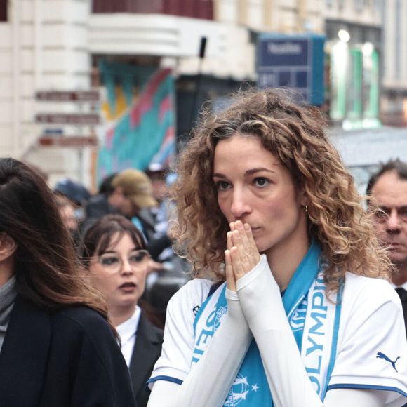 "Je suis un petit peu émue, ma vie a pris une sortie de route inattendue et violente ces derniers jours. Je voudrais remercier les clubs de foot, les rédactions de sport pour leurs marques de sympathie."

Clara Paban (femme de R.Courbis) et Olivia Courbis (fille de R.Courbis) - Obsèques de Rolland Courbis en l'église des Réformés à Marseille, France, le 17 janvier 2026. © Adrien Pittore/PsnewZ/Bestimage