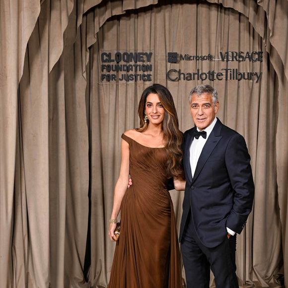 L’avocate portait une somptueuse robe drapée chocolat signée Versace, qui sublimait sa silhouette avec élégance.

Amal Clooney et son époux, George Clooney lors de la cérémonie des Albies au Musée d’Histoire naturelle de Londres. Photo par Backgrid UK/ Bestimage