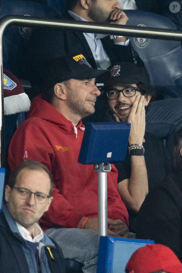 Michaël Youn et Sean Obispo - Célébrités des les tribunes lors du match aller du quart de finale de Ligue des champions entre le PSG et Aston Villa (3-1) au Parc des Princes à Paris le 9 avril 2025. © Cyril Moreau/Bestimage
