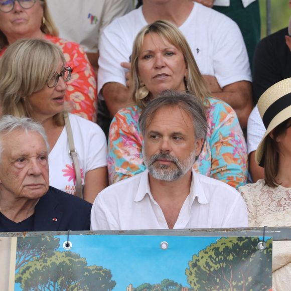 Semi-exclusif - Michel Sardou, Romain Sardou et sa compagne Kym Thiriot enceinte - Michel Sardou rend hommage à son père en famille lors du premier trophée de pétanque "Fernand Sardou" à Bormes-les-Mimosas le 29 mai 2026. Le célèbre chanteur est venu en famille avec sa femme, son fils Romain avec son fils de deux ans et demi et de sa compagne enceinte de son deuxième enfant.
La première édition du Trophée Fernand Sardou est organisée du 29 au 31 mai au coeur du village de Bormes les Mimosas. Une initiative portée par Michel et son fils Romain, pour rendre hommage à leur illustre parent Fernand Sardou au travers d'un tournoi de pétanque.
En lien avec la municipalité et l'Amicale Bouliste Borméenne (ABB), un premier Trophée Fernand Sardou sera organisé avec deux grands temps forts : Le vendredi, dès 18h, un tournoi d'exhibition sera proposé et verra s'affronter 16 triplettes. Puis un concours fédéral à pétanque sera organisé le weekend et ouvert à tous les amateurs. 128 équipes seront réparties sur les sites les plus emblématiques du village, à savoir au boulodrome de la place Saint-François, mais aussi au parc Cigalou, sur le site du château et à l'ancien stade. © Franz Chavaroche/Bestimage