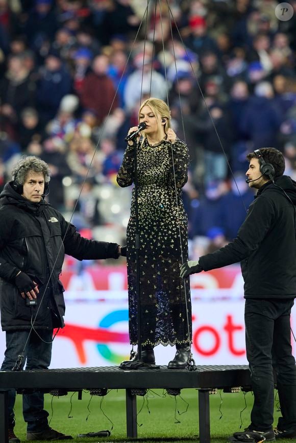 La chanteuse Louane (Louane Emera), représentante de la France au concours de l'Eurovision, interpréte pour la première fois son titre "maman", en hommage à sa mère décédée lorsqu'elle avait 17 ans, devant les 80 000 spectateurs, suspendue sur une plateforme, plusieurs mètres au-dessus de la pelouse et des musiciens, du Stade de France à la mi-temps du match du Tournoi des Six Nations opposant la France à l'Écosse, à Saint-Denis, Seine Saint-Denis, France, le 15 mars 2025. © Cyril Moreau/Bestimage