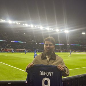 Le demi de mêlée français de Toulouse Antoine Dupont pose avec son propre maillot du PSG portant son nom lors du match de football de Ligue 1 entre le Paris Saint-Germain (PSG) et Auxerre au stade du Parc des Princes à Paris, France, le 27 septembre 2025. Photo by Henri Szwarc/ABACAPRESS.COM