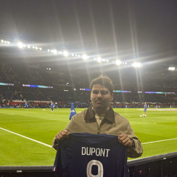 Le demi de mêlée français de Toulouse Antoine Dupont pose avec son propre maillot du PSG portant son nom lors du match de football de Ligue 1 entre le Paris Saint-Germain (PSG) et Auxerre au stade du Parc des Princes à Paris, France, le 27 septembre 2025. Photo by Henri Szwarc/ABACAPRESS.COM