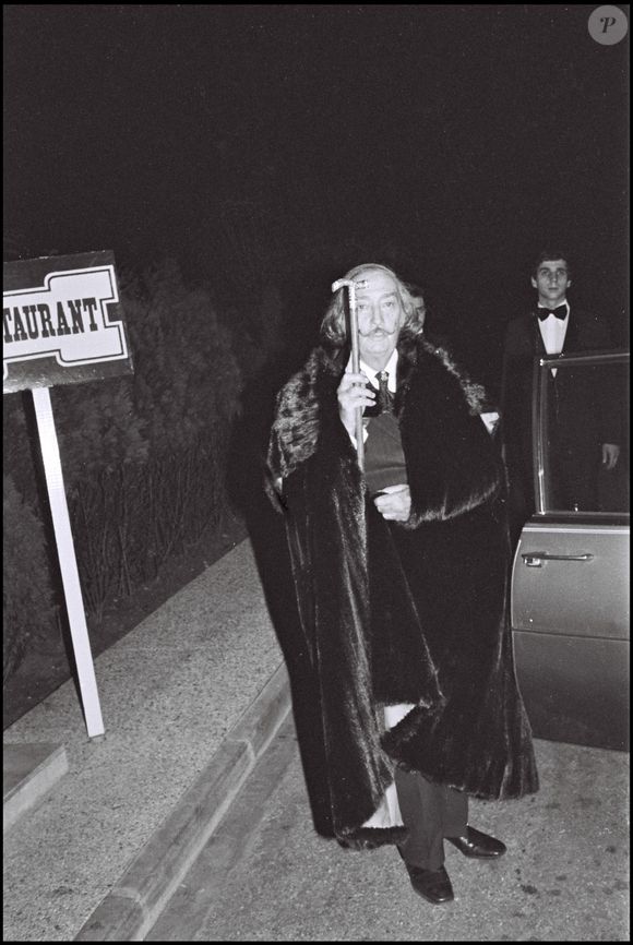 ARCHIVES - SALVADOR DALI ARRIVANT A UNE SOIREE
