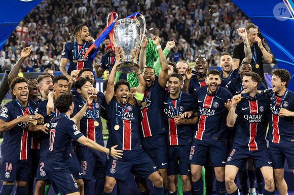 Marquinhos soulève la coupe aux grandes oreilles avec ses coéquipiers Nuno Mendez, Willian pacho, Fabian Ruiz, Gianluigi Donnaruma,  Désiré Doué, Achraf Hakiml, Vitinha, Joao Neves, Khvicha Kvaratskhelia, Ousmane Dembélé, Presnel Kimpembe, Lucas Beraldo, Matvei Safonov, Kang-In Lee et Luis Enrique - Le PSG remporte la Ligue Des Champions 2025, pour la première fois de son histoire, face à l'Inter Milan (5-0) à l'Allianz Arena de Munich, le 31 mai 2025. © Cyril Moreau/Bestimage