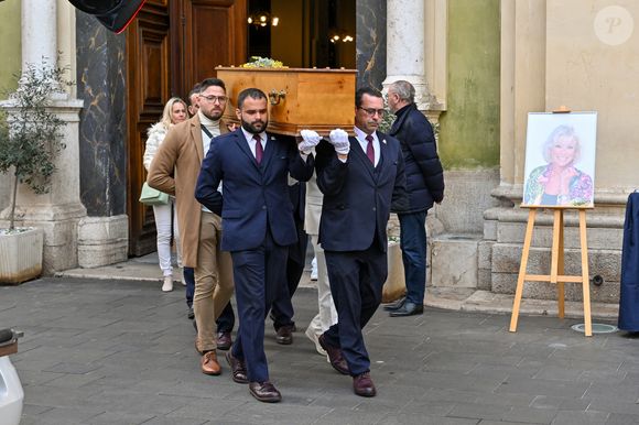 Le cercueil de la défunte avec Céline Olive (fille de E.Leclercq) à la sortie des obsèques d'Evelyne Leclercq en la cathédrale Sainte-Réparate de Nice, France, le 13 janvier 2026. Une tenue blanche ou claire est souhaitée pour la cérémonie. Ni fleurs, ni couronnes. Selon la volonté de la défunte Evelyne, des dons en faveur du pôle cancérologie Arnault Tzanck pourront être effectués par chèque à l'ordre de FDD AAT ou via un lien numérique HelloAsso - Campagne de dons, Institut du Cancer de Mougins. © Bruno Bebert/Bestimage