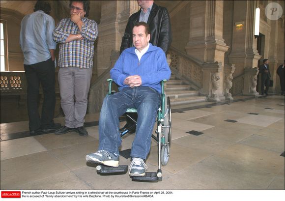 L'écrivain français Paul-Loup Sulitzer arrive assis dans un fauteuil roulant au palais de justice de Paris (France) le 28 avril 2004. Il est accusé d'abandon de famille par sa femme Delphine. Photo Hounsfield/Gorassini/ABACA.