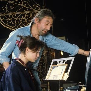 En France, à Paris, Serge Gainsbourg chez lui avec sa fille Charlotte dans son hôtel particulier de la rue de Verneuil, posant au milieu de son bric-à-brac où il entasse des objets hétéroclites en mai 1985.  © Michel Marizy via Bestimage