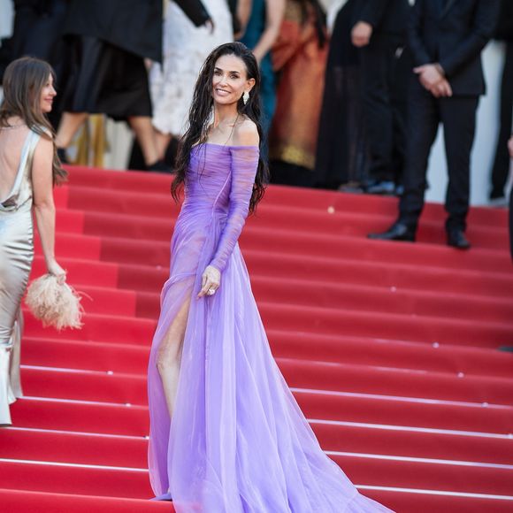 Pour la montée des marches de "La Vie d’une Femme", elle a opté pour une robe violette transparente signée Gucci, inspirée d’un look qu’elle portait déjà en 2003 à l’avant-première de "Matrix Reloaded"

Demi Moore - Montée des marches du film " La vie d'une femme " lors du 79ème Festival International du Film de Cannes, le 13 mai 2026. © Jacovides-Moreau / Bestimage