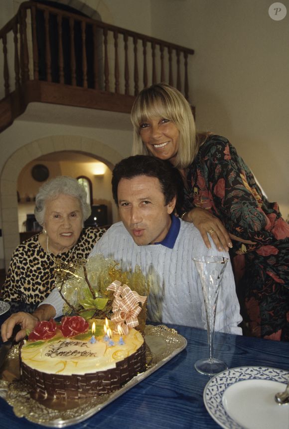 En France, dans sa maison de vacances en Provence, Michel Drucker, sa mère Lola et sa femme Dany Saval, devant le gâteau d'anniversaire pour les 50 ans de Michel Drucker. Septembre 1992
© Alain Canu via Bestimage