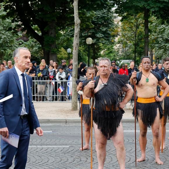 Les journalistes de la chaîne de télévision TF1 Gilles Bouleau et Anne-Claire Coudray avec les guerriers maoris de Nouvelle-Zélande lors de la célébration du Jour de la Bastille 2016, sur les Champs-Élysées à Paris, France, le 14 juillet 2016. Photo de Henri Szwarc/ABACAPRESS.COM