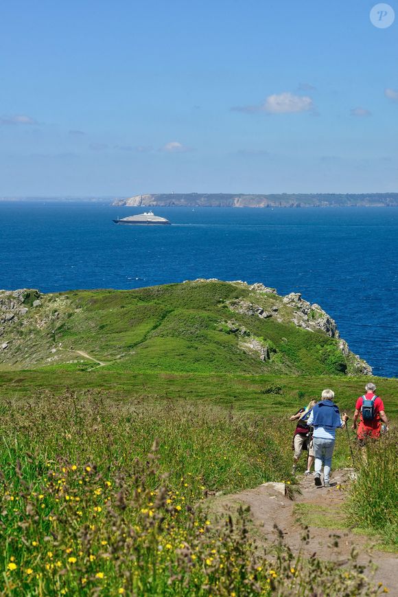 Beuzec-Cap-Sizun (29) : randonneurs sur le sentier cotier du GR34 au niveau de Kastel Koz, vue sur le cap de la Chevre, presqu'ile de Crozon, et vue sur le navire yacht de luxe Scenic Eclipse - Photo by Roignant JM/ANDBZ/ABACAPRESS.COM