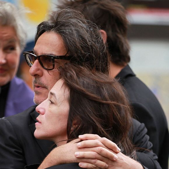 Alors elle tente de combler ce vide comme elle le peut. Charlotte Gainsbourg révèle ainsi vivre avec un objet ayant appartenu à sa mère. 
Yvan Attal et Charlotte Gainsbourg - Sorties des obsèques de Jane Birkin en l'église Saint-Roch à Paris. Le 24 juillet 2023
© Jonathan Rebboah / Panoramic / Bestimage