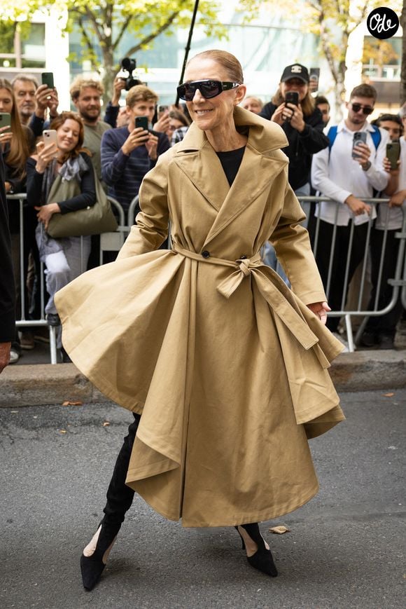 Elle portait un spectaculaire trench beige asymétrique associé à une tenue noire très ajustée.

Céline Dion acclamée par ses fans à son arrivée au palace Royal Monceau à Paris, le 28 août 2026. Phoot par CYRIL MOREAU / BESTIMAGE