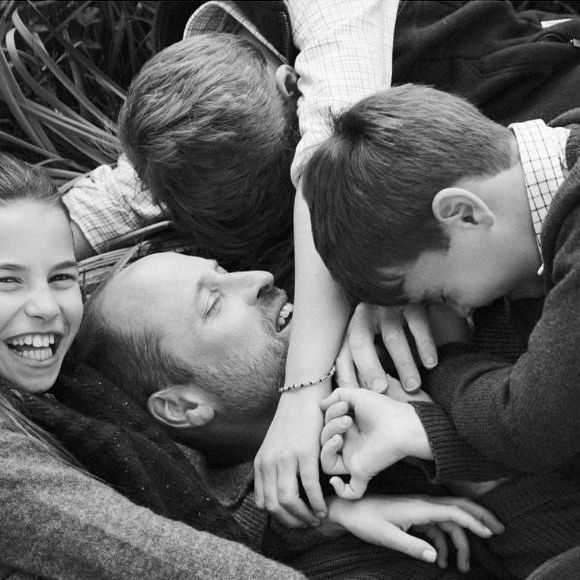 Sur la seconde, les princes George et Louis, accompagnés de leur sœur, la princesse Charlotte, se jettent sur leur père.  Les sourires sont partagés et la bonne humeur de cet instant de complicité transparaît à l’écran.

Le prince William et ses enfants, la princesse Charlotte, le prince Louis et le prince George, prennent la pose à l'occasion de la fête des pères du 15 juin 2025 © Josh Shinner