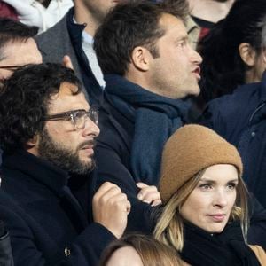 Maxim Nucci (Yodelice) et sa compagne Isabelle Ithurburu dans les tribunes lors du match de rugby du Tournoi des 6 Nations opposant la France à l'Angleterre au stade de France, à Saint-Denis, Seine Saint-Denis, France, le 19 mars 2022. © Cyril Moreau/Bestimage