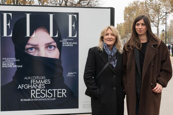 Veronique Philipponat, PDG de Elle (G) et la journaliste Ava Djamshidi (D) posent devant la couverture du magazine Elle lors du vernissage de l'exposition de photographies en plein air "Avec les femmes afghanes - Résister", sur les Champs Elysées, à Paris, France, le 15 novembre 2021. Photograph by Daniel Derajinski / ABACAPRESS.COM