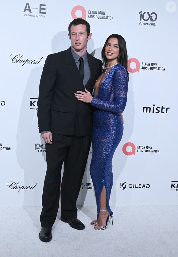 Pour l'occasion, la musicienne portait un tailleur jupe blanc personnalisé de Schiaparelli couture, conçu par Daniel Roseberry.

Callum Turner et Dua Lipa à la 34e soirée de visionnage des Oscars de la Fondation Elton John AIDS le 15 mars 2026 à West Hollywood, Californie. Credit : Michael Mattes / AdMedia (Credit Image : © Michael Mattes/AdMedia via ZUMA Press / Bestimage Wire / Bestimage)