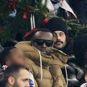 Gims et sa femme DemDem dans les tribunes du match de Ligue 1 McDonald's opposant le Paris Saint-Germain (PSG) à Lyon (3-1) au Parc des Princes à Paris le 15 décembre 2024. © Cyril Moreau/Bestimage