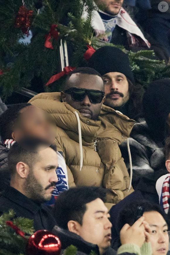 Gims et sa femme DemDem dans les tribunes du match de Ligue 1 McDonald's opposant le Paris Saint-Germain (PSG) à Lyon (3-1) au Parc des Princes à Paris le 15 décembre 2024. © Cyril Moreau/Bestimage