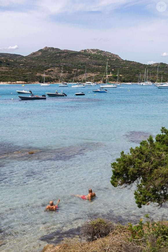 Corse : la baie de Santa Giulia avec bateaux au mouillage et deux hommes dans l'eau translucide, Corse du Sud - Photo de Delmarty J/ANDBZ/ABACAPRESS.COM
