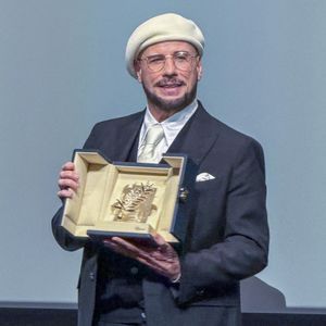 Pour honorer ce nouveau statut de metteur en scène, l'acteur s'est donc inspiré des plus grands maîtres de l'histoire du cinéma. "J'ai cherché des photos des années 20, 30, 40, 50 et 60, et les réalisateurs de la vieille école portaient des bérets et des lunettes."

John Travolta reçoit une Palme d'or d'honneur surprise lors du 79ème Festival International du Film de Cannes (12 - 23 mai 2026), le 15 mai 2026.